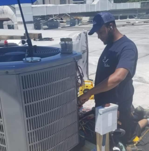 An HVAC technician servicing an outdoor AC unit on a rooftop for Gordon's Heating & A/C in Newport News, VA.