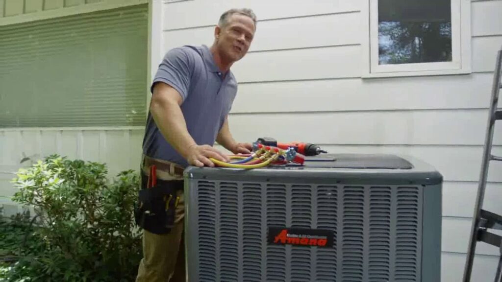 An HVAC technician servicing an outdoor air conditioning unit for Griffin HVAC in Peoria, IL