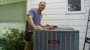An HVAC technician servicing an outdoor air conditioning unit for Griffin HVAC in Peoria, IL