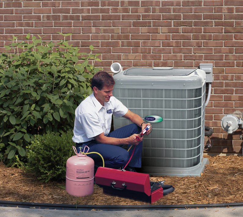 An HVAC technician servicing an outdoor air conditioning unit with gauges and refrigerant at Harry Roberts Plumbing Heating Air Conditioning in Owensboro, KY.