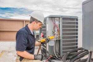 An HVAC technician servicing an outdoor air conditioning unit for Icy Hot HVAC in Spartanburg, SC
