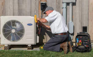 An HVAC technician servicing an outdoor Carrier air conditioning unit for RSC Heating and Air Conditioning in Lancaster, PA.