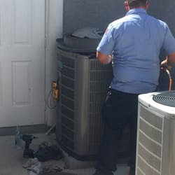 An HVAC technician servicing an outdoor air conditioning unit for Sahara Air Conditioning & Heating in Las Vegas, NV