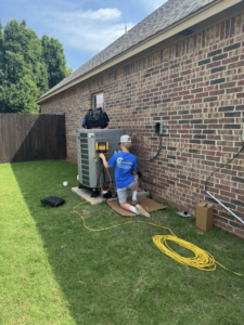 An HVAC technician from Thomas Mechanical Services Corp servicing an outdoor AC unit in Edmond, OK.