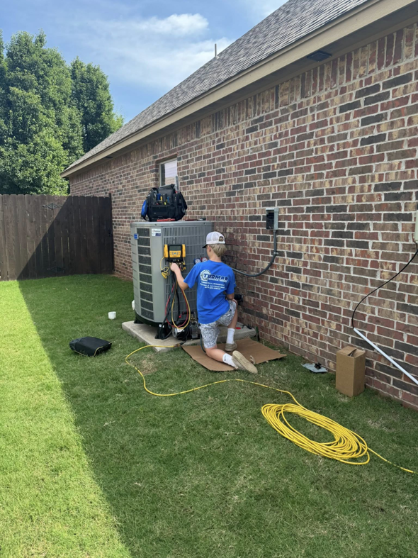 An HVAC technician from Thomas Mechanical Services Corp servicing an outdoor AC unit in Edmond, OK.