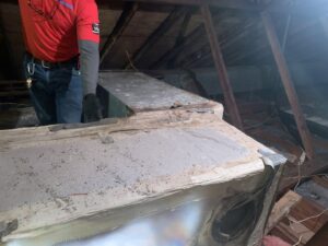 An HVAC technician servicing an air handler or furnace unit in an attic space for Keith HVAC & Electrical Enterprises LLC in New Orleans, LA.