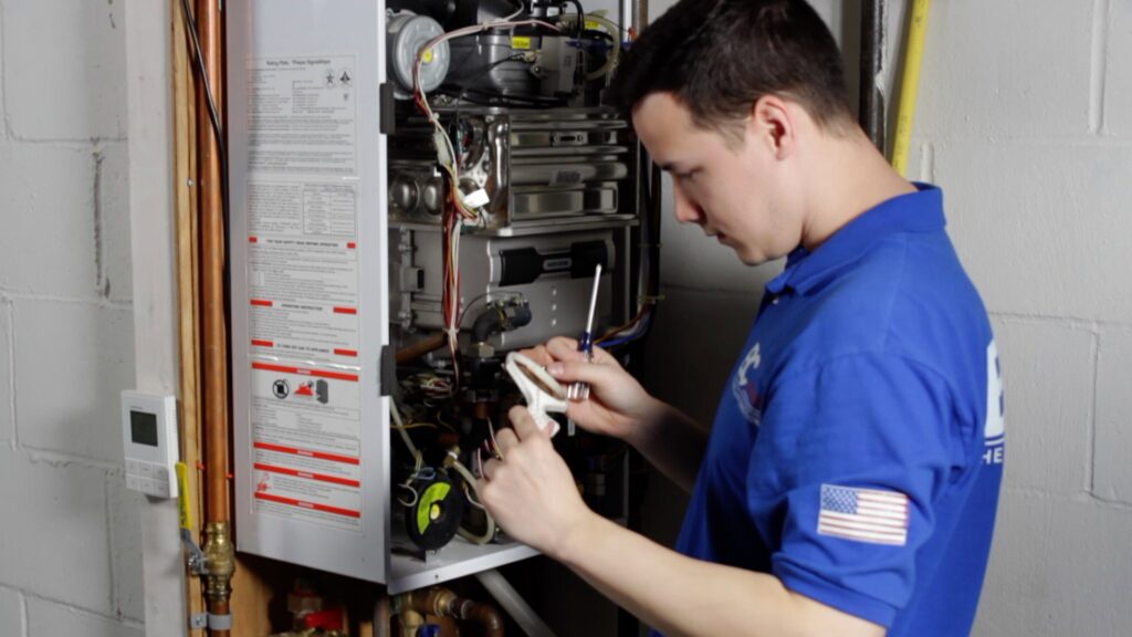 An HVAC technician from BC Express Inc Heating & Air Conditioning servicing an indoor boiler in Toms River, NJ.