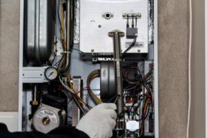 An HVAC technician servicing the internal components of a boiler for General Air Conditioning Service Corp in Greenville, SC.