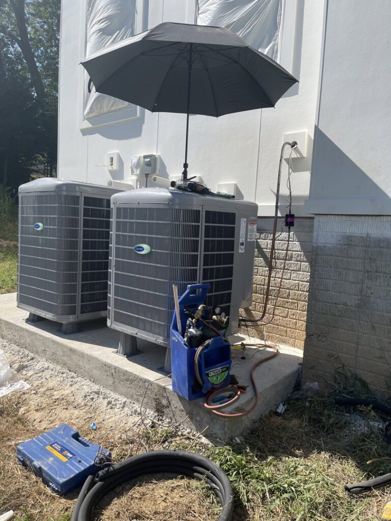 A Vanessa Service HVAC technician servicing Carrier outdoor air conditioning units with tools and gauges in Falls Church, VA.