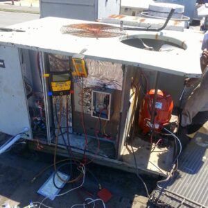 An HVAC technician servicing a large commercial rooftop air conditioning unit for Calloway & Sons A/C And Heating in New Orleans, LA.
