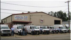 An HVAC technician servicing a commercial rooftop AC unit with diagnostic tools from Taylor & Tyler HVAC, New Orleans, LA.