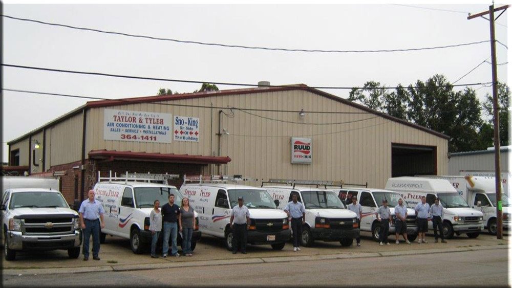 An HVAC technician servicing a commercial rooftop AC unit with diagnostic tools from Taylor & Tyler HVAC, New Orleans, LA.