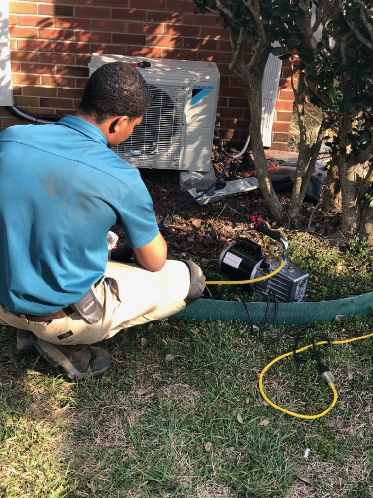 An HVAC technician servicing an outdoor Daikin mini-split unit at a client's home for Relief Heating and Cooling, LLC in Greensboro, NC.