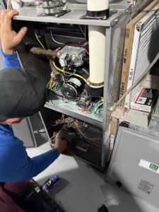 An HVAC technician from Total HVAC - Heating and Cooling performing service inside a furnace in Nashville, TN.