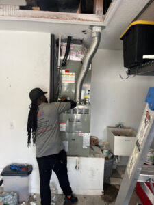 An HVAC technician servicing a furnace unit in a garage for Timely Air Conditioning in Riverview, FL.