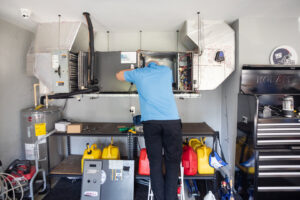 An HVAC technician servicing an indoor furnace and ductwork system for Surfside Heating & Cooling in Cape Coral, FL.