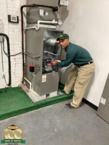 A Berico HVAC technician servicing an indoor furnace or air handler unit in Greensboro, NC