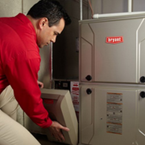 An HVAC technician servicing an indoor furnace unit by Dan Deckard Hvac in Charlotte, NC