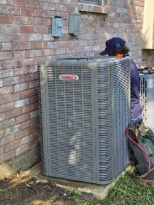 An HVAC technician servicing an outdoor Lennox condenser unit at a residential property for Harlen Johnson Heating & Air in Dallas, TX.