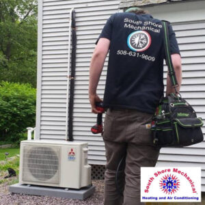 An HVAC technician servicing an outdoor mini-split unit for South Shore Mechanical in Abington, MA