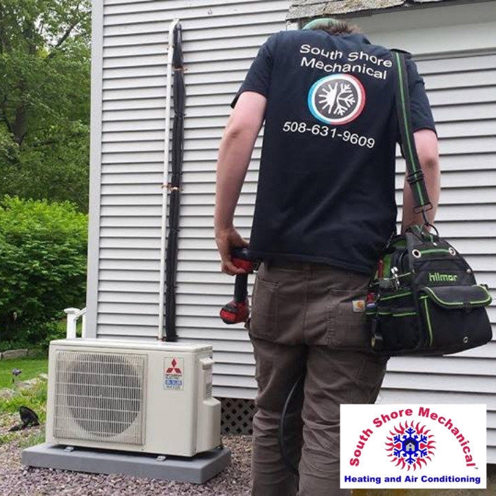 An HVAC technician servicing an outdoor mini-split unit for South Shore Mechanical in Abington, MA
