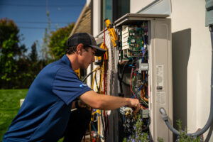 An HVAC technician servicing an outdoor mini-split unit for Hurn Mechanical Heating & Cooling in El Cajon, CA.