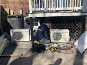 An HVAC technician servicing outdoor mini-split condenser units for Air Energy Solutions in North Chesterfield, VA