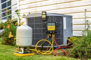 An outdoor AC unit with diagnostic tools connected, being serviced by General Air Conditioning Service Corp in Greenville, SC.