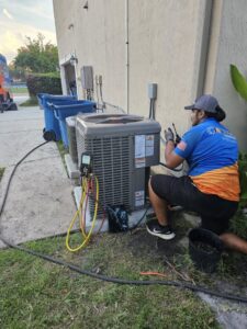 An HVAC technician servicing an outdoor air conditioning unit for J&W Heating and Air + Plumbing in Jacksonville, FL.