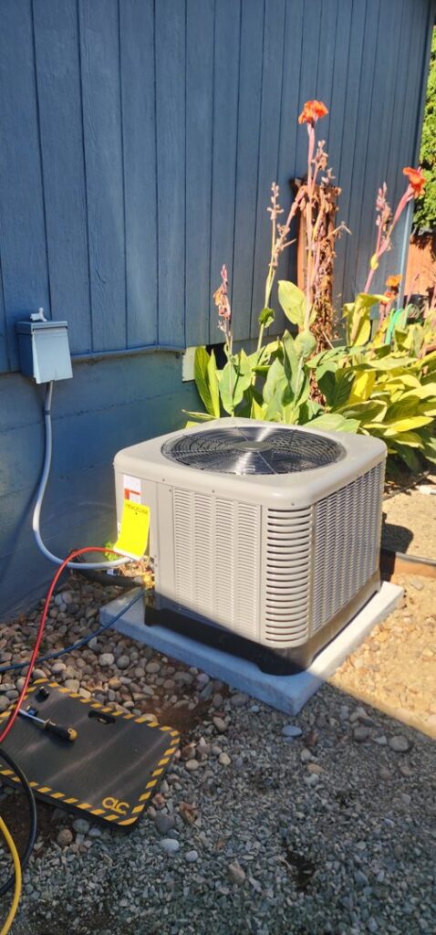 An HVAC technician from Nelke Mechanical servicing an outdoor air conditioning unit with tools and gauges in Keizer, OR.