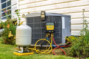 An outdoor AC unit being serviced with gauges and tools, demonstrating HVAC work by NorthStar Services in South Haven, MN