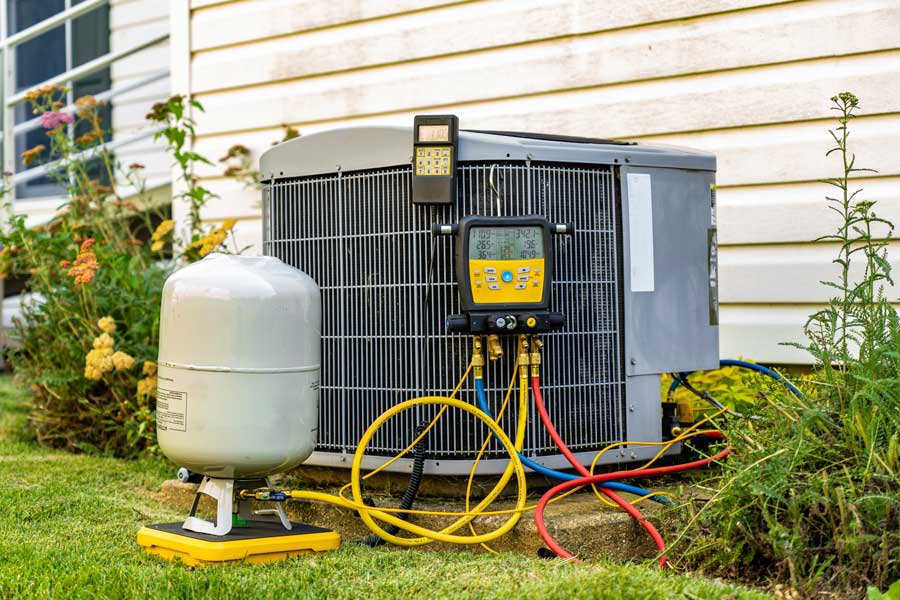 An outdoor AC unit being serviced with gauges and tools, demonstrating HVAC work by NorthStar Services in South Haven, MN
