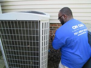 An HVAC technician servicing the side panel of an outdoor AC unit for On Call Plumbing, Heating & Air in Columbia, SC