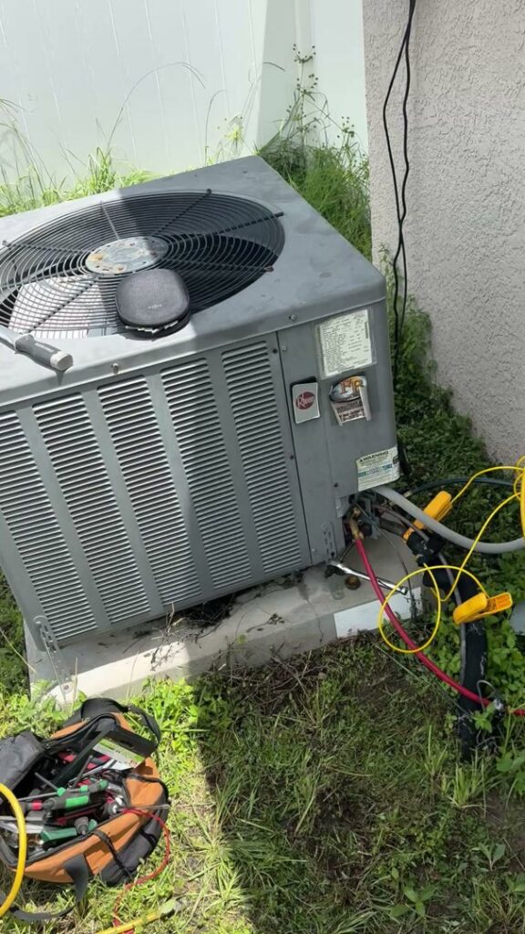 An HVAC technician servicing an outdoor AC unit with gauges connected for Timely Air Conditioning in Riverview, FL.
