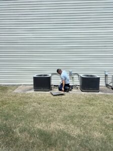 A Triune Air HVAC technician servicing outdoor air conditioning units at a commercial property in Smithville, TN.