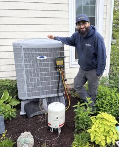 An HVAC technician from A All Temp Inc. Heating & Cooling servicing an outdoor unit in Naperville, IL.