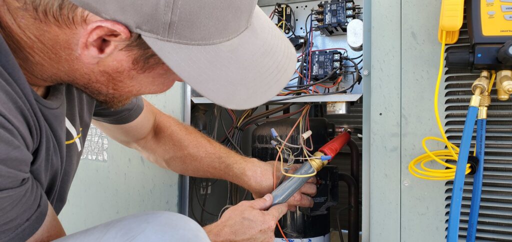 An HVAC technician from Arrow Pro Services servicing an outdoor air conditioning unit in Gilbert, AZ