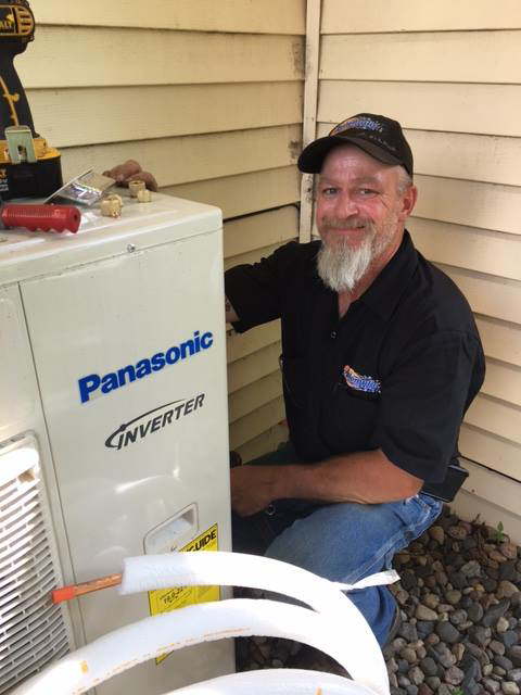 An HVAC technician servicing an outdoor Panasonic Inverter unit for Automatic Heating And Air Inc. in Fargo, ND
