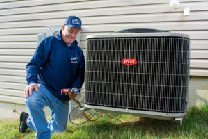 A Burks Service Company HVAC technician servicing an outdoor Bryant air conditioning unit in Columbia, MO.