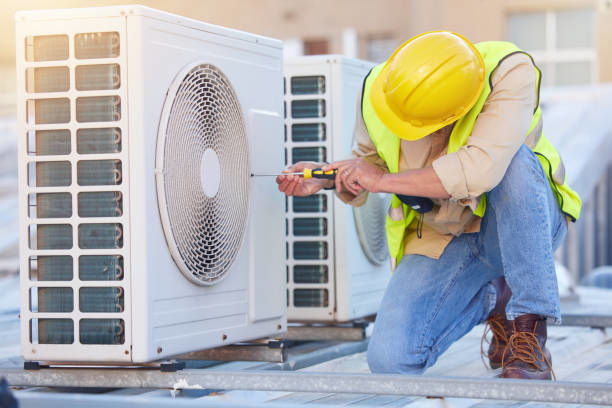 An HVAC technician servicing an outdoor air conditioning unit for Commercial Air Condition Service, Inc. in Greenville, SC