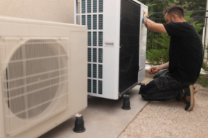 An HVAC technician servicing an outdoor air conditioning unit for Controlled Climate Solutions in Decatur, AL.