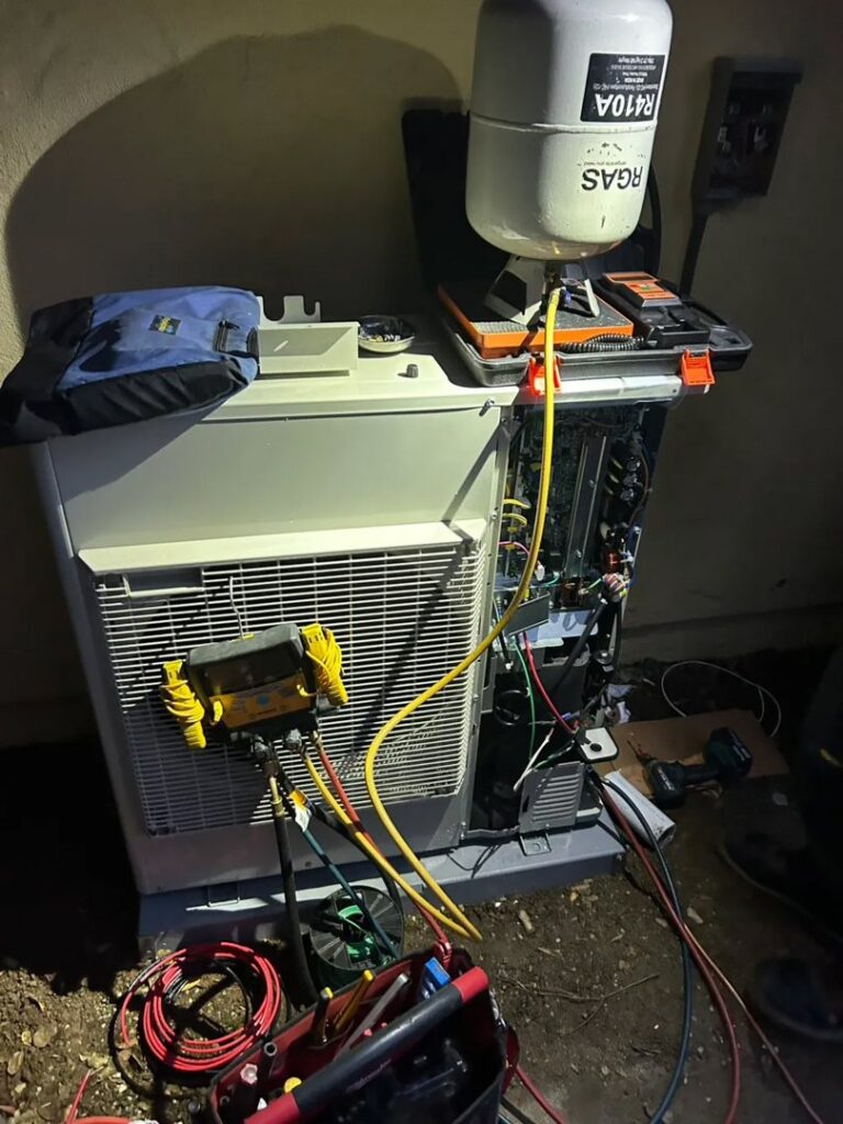 An HVAC technician from Fuse HVAC & Appliance Repair Boston servicing an outdoor unit with gauges in West Roxbury, MA.