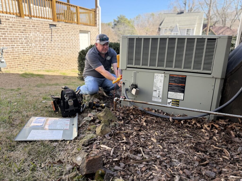 An HVAC technician performing service on an outdoor heating and air conditioning unit for Southern Comfort Heating & Air, LLC in Chattanooga, TN.
