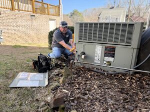An HVAC technician performing service on an outdoor heating and air conditioning unit for Southern Comfort Heating & Air, LLC in Chattanooga, TN.