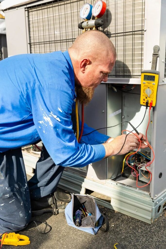 An HVAC technician servicing an outdoor unit with gauges and a multimeter for Heating & Air Paramedics - Tucson in Tucson, AZ.