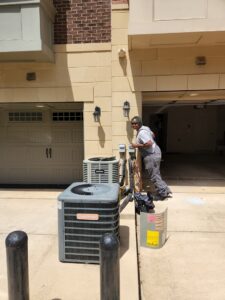 An HVAC technician servicing outdoor condenser units for ECA DuctWorks in Reston, VA