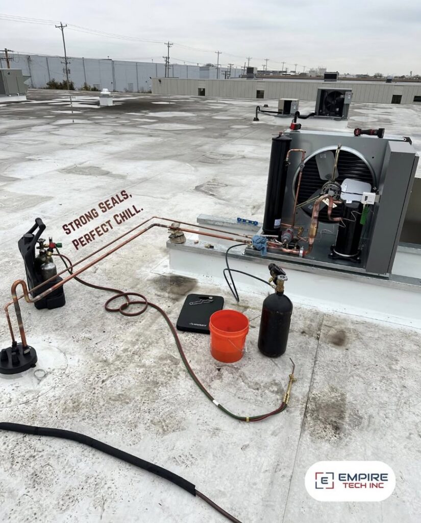 An Empire Tech, Inc. technician servicing a rooftop HVAC refrigeration unit in Schaumburg, IL.