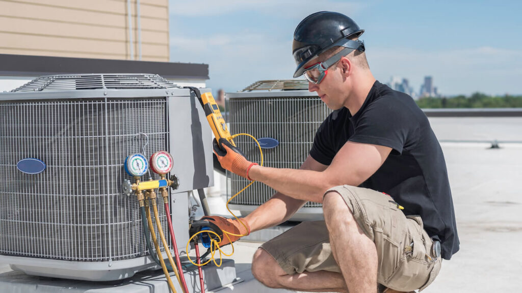 An HVAC technician performing service on a rooftop air conditioning unit for Boykin Air Conditioning Services in Sumter, SC.