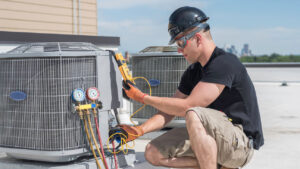 An HVAC technician performing service on a rooftop air conditioning unit for Boykin Air Conditioning Services in Sumter, SC.