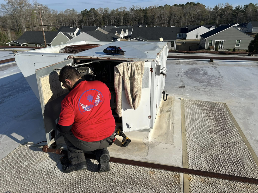 An HVAC technician servicing a commercial rooftop unit for Angel's Air Heating & Cooling, LLC in Lakeland, FL.